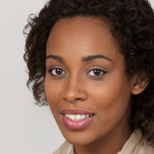 Joyful black young-adult female with long  brown hair and brown eyes