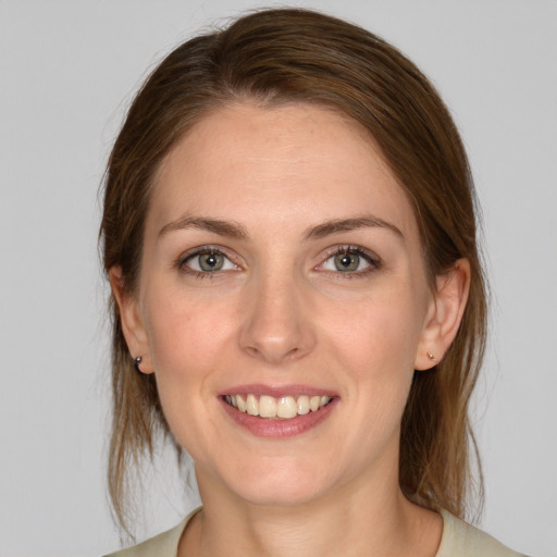 Joyful white young-adult female with medium  brown hair and grey eyes