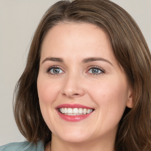 Joyful white young-adult female with medium  brown hair and blue eyes