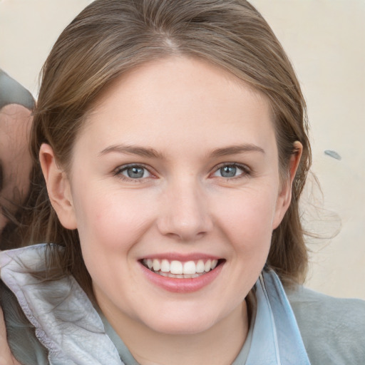 Joyful white young-adult female with medium  brown hair and blue eyes