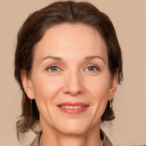 Joyful white adult female with medium  brown hair and grey eyes