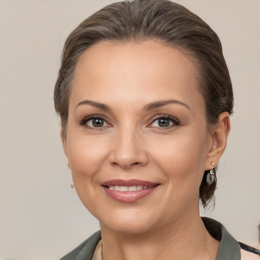 Joyful white adult female with medium  brown hair and brown eyes