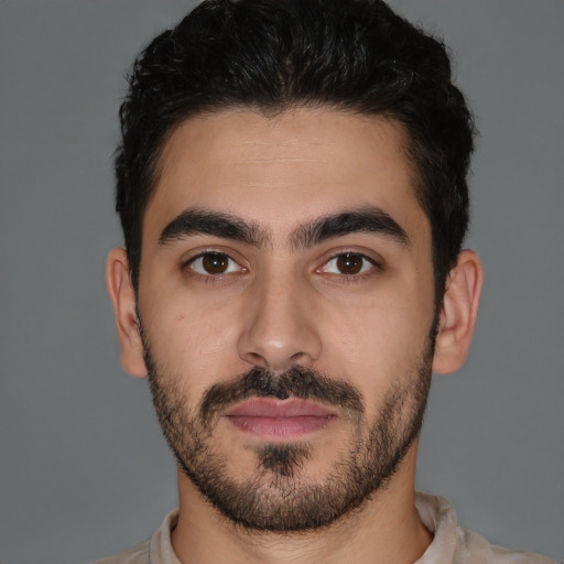 Joyful latino young-adult male with short  brown hair and brown eyes