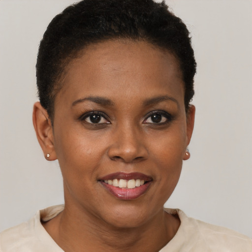 Joyful black young-adult female with short  brown hair and brown eyes