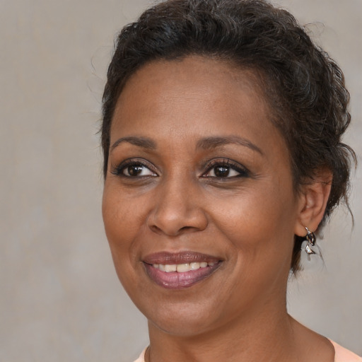 Joyful black adult female with medium  brown hair and brown eyes