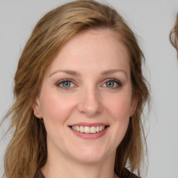 Joyful white young-adult female with medium  brown hair and grey eyes