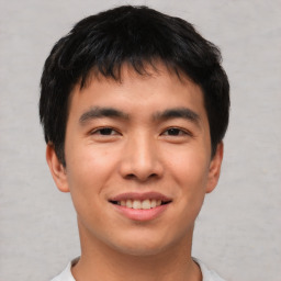 Joyful asian young-adult male with short  brown hair and brown eyes