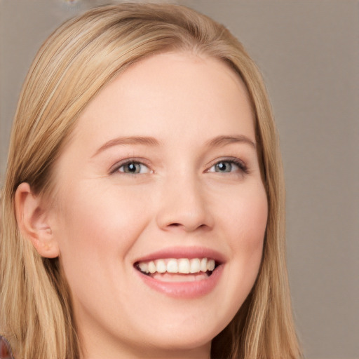 Joyful white young-adult female with long  blond hair and grey eyes