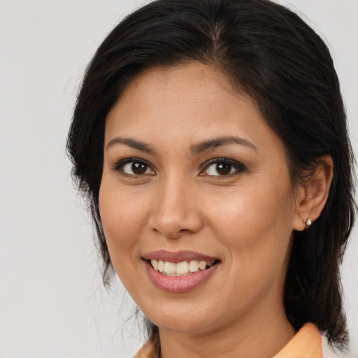 Joyful latino young-adult female with long  brown hair and brown eyes