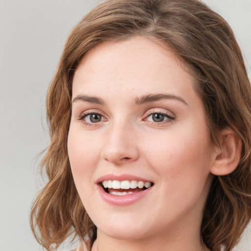 Joyful white young-adult female with medium  brown hair and green eyes