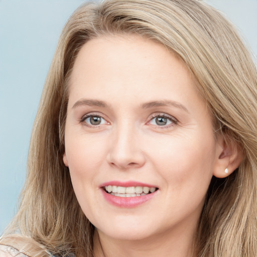 Joyful white young-adult female with long  brown hair and blue eyes