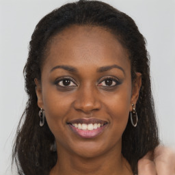 Joyful black young-adult female with long  brown hair and brown eyes