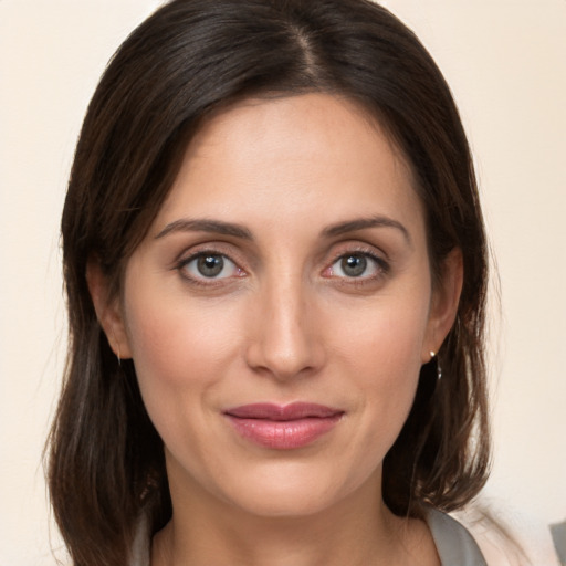 Joyful white young-adult female with medium  brown hair and grey eyes