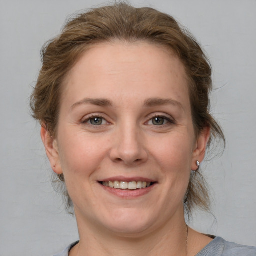 Joyful white young-adult female with medium  brown hair and grey eyes