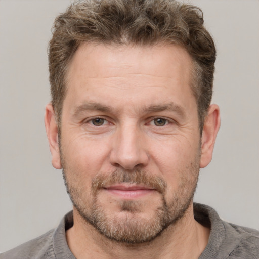 Joyful white adult male with short  brown hair and grey eyes