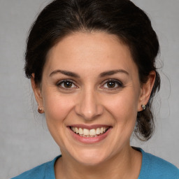 Joyful white adult female with medium  brown hair and brown eyes