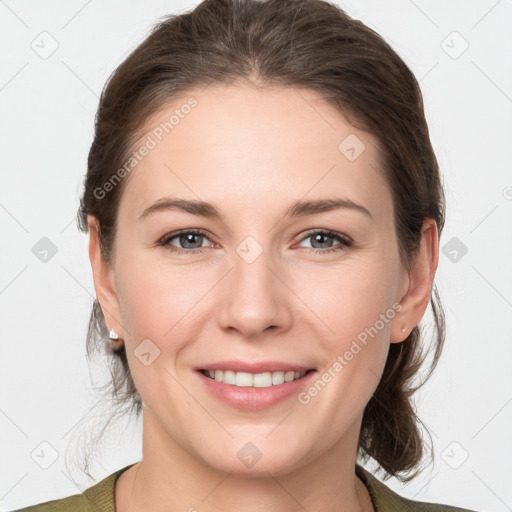 Joyful white young-adult female with medium  brown hair and grey eyes