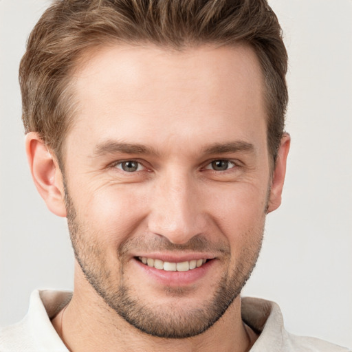 Joyful white young-adult male with short  brown hair and grey eyes