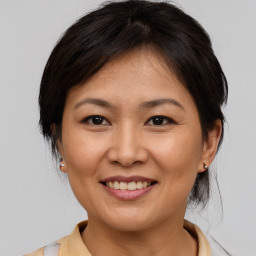 Joyful asian young-adult female with medium  brown hair and brown eyes