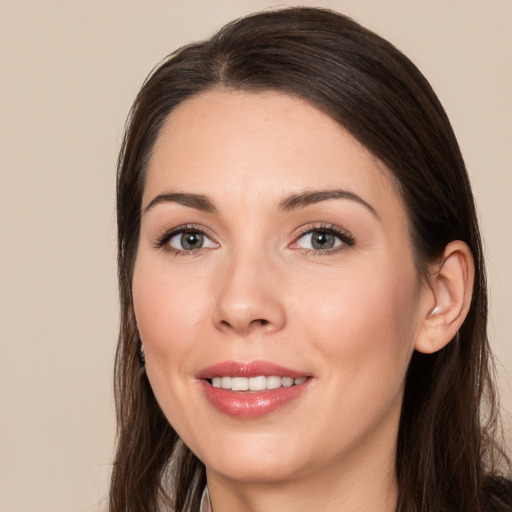 Joyful white young-adult female with long  brown hair and brown eyes