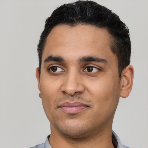 Joyful latino young-adult male with short  black hair and brown eyes