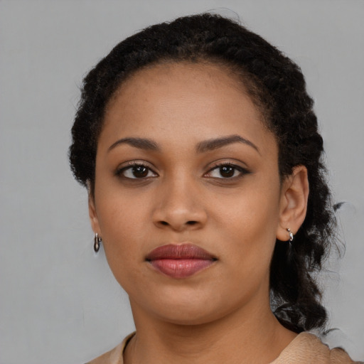 Joyful black young-adult female with long  brown hair and brown eyes