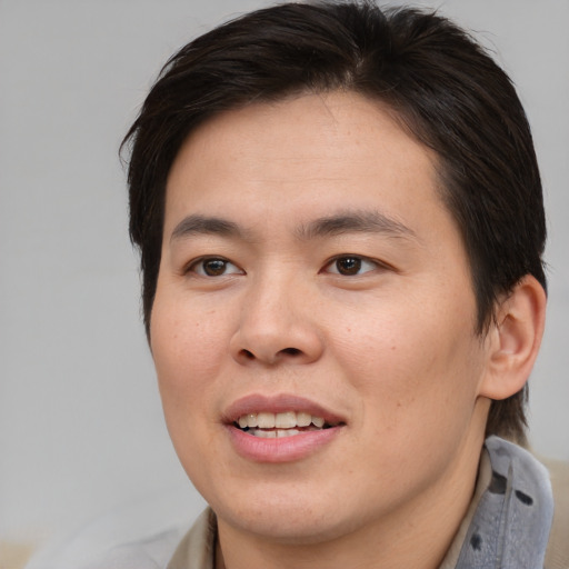 Joyful asian young-adult male with medium  brown hair and brown eyes
