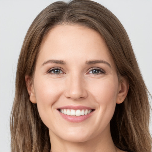 Joyful white young-adult female with long  brown hair and grey eyes