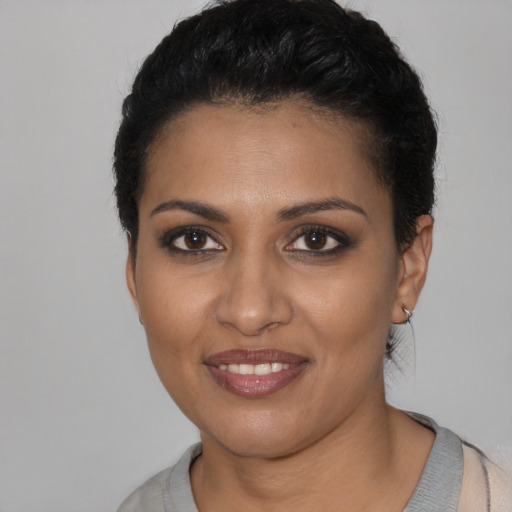 Joyful black young-adult female with short  black hair and brown eyes
