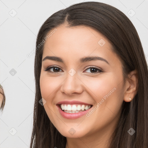 Joyful white young-adult female with long  brown hair and brown eyes