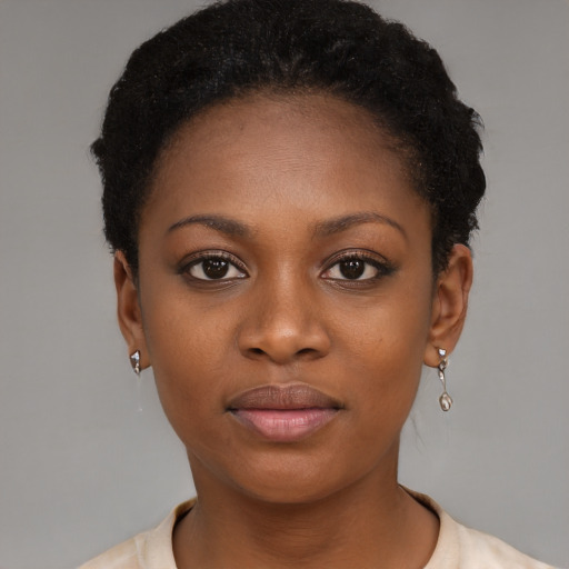 Joyful black young-adult female with short  black hair and brown eyes