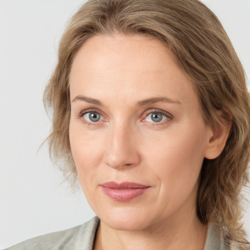 Joyful white young-adult female with medium  brown hair and blue eyes