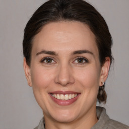 Joyful white adult female with medium  brown hair and grey eyes