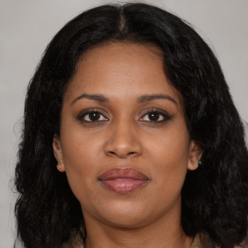Joyful black young-adult female with long  black hair and brown eyes