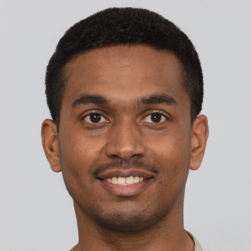 Joyful black young-adult male with short  black hair and brown eyes