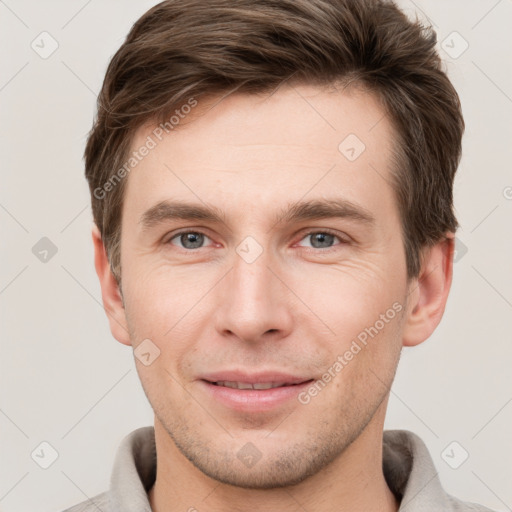 Joyful white young-adult male with short  brown hair and grey eyes