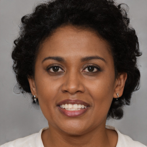 Joyful latino adult female with medium  brown hair and brown eyes