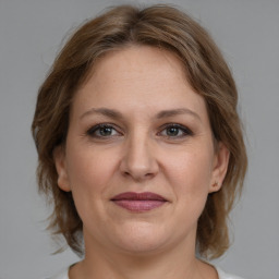 Joyful white adult female with medium  brown hair and grey eyes