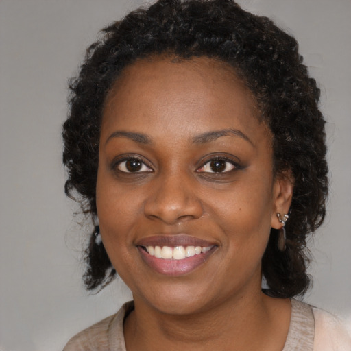 Joyful black young-adult female with long  black hair and brown eyes