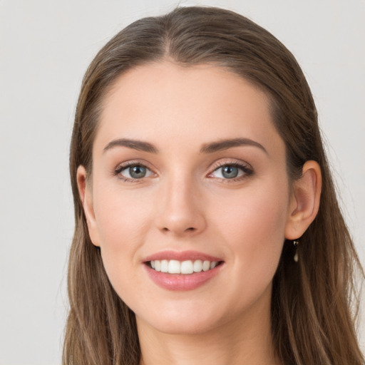 Joyful white young-adult female with long  brown hair and grey eyes