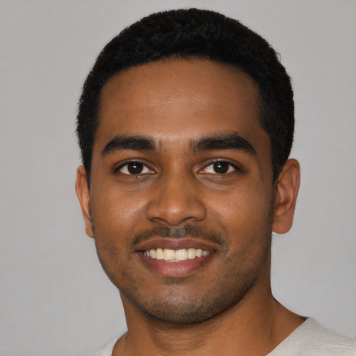 Joyful black young-adult male with short  black hair and brown eyes