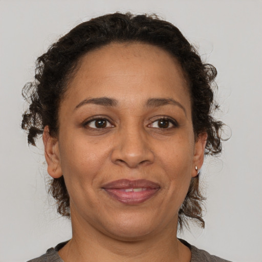 Joyful latino adult female with medium  brown hair and brown eyes