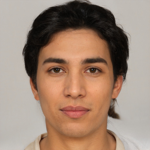 Joyful latino young-adult male with short  brown hair and brown eyes