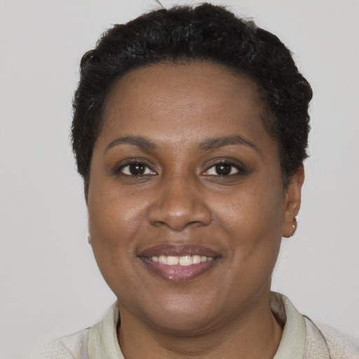 Joyful black young-adult female with short  brown hair and brown eyes