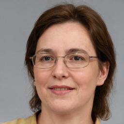 Joyful white adult female with medium  brown hair and blue eyes