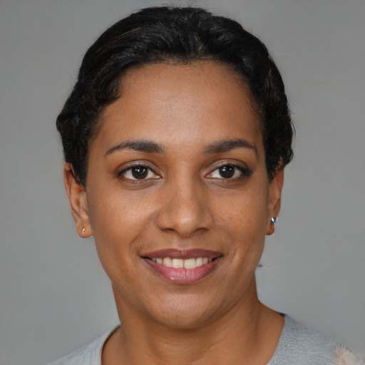 Joyful latino young-adult female with short  black hair and brown eyes
