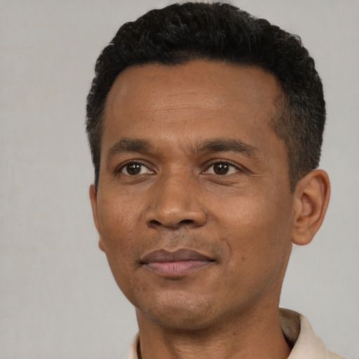 Joyful black adult male with short  black hair and brown eyes