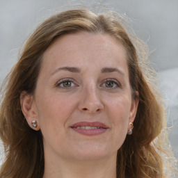 Joyful white adult female with long  brown hair and grey eyes