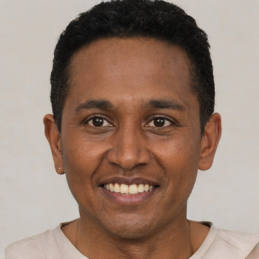 Joyful black young-adult male with short  black hair and brown eyes