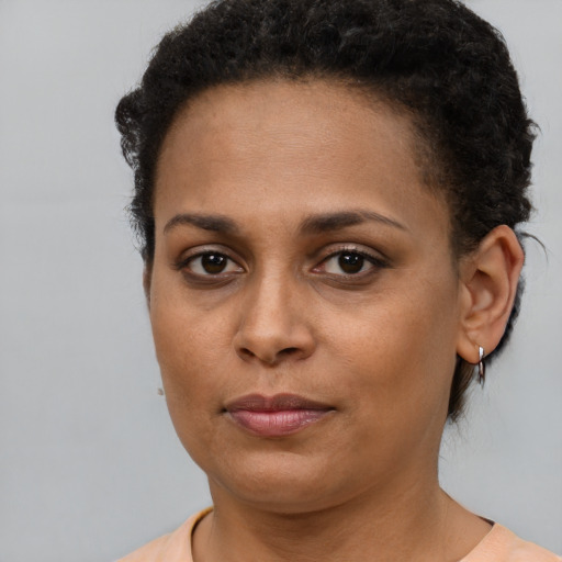 Joyful black young-adult female with short  brown hair and brown eyes